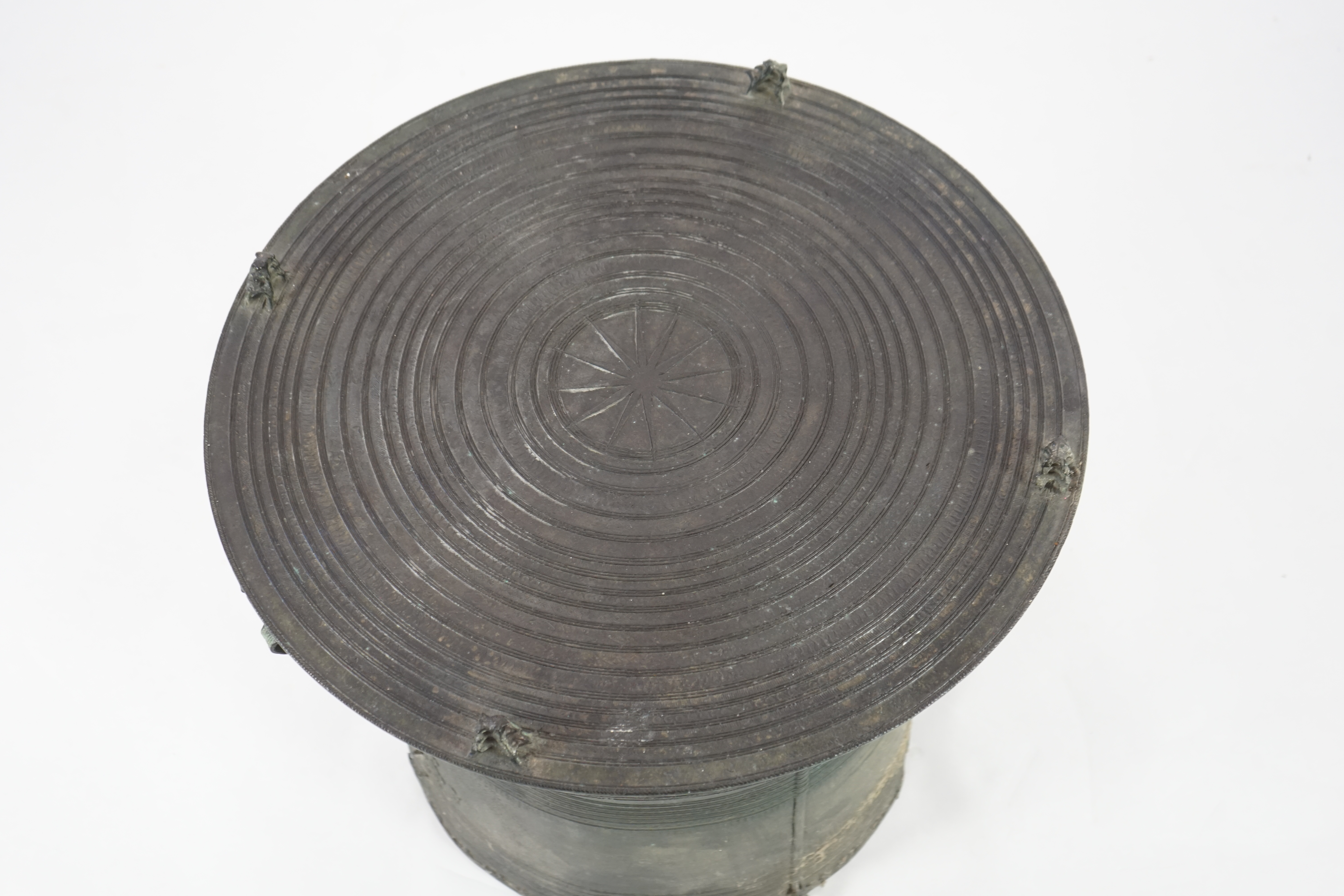 A Shan States bronze rain drum, the concentric ring decorated top mounted with stylised frogs, sides with loop handles and raised ring decoration, 66cm diameter, 57cm high